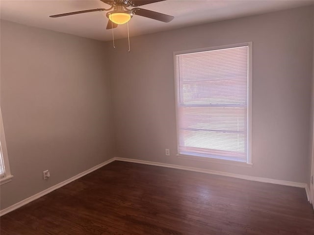 empty room featuring dark wood-type flooring and ceiling fan