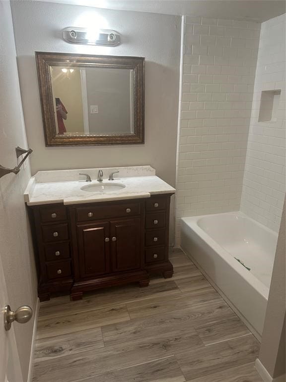 bathroom featuring vanity, hardwood / wood-style flooring, and tiled shower / bath combo