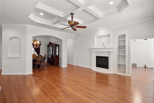 unfurnished living room featuring hardwood / wood-style floors, coffered ceiling, ceiling fan with notable chandelier, ornamental molding, and beam ceiling