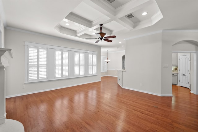 unfurnished living room featuring coffered ceiling, a healthy amount of sunlight, crown molding, and light hardwood / wood-style flooring