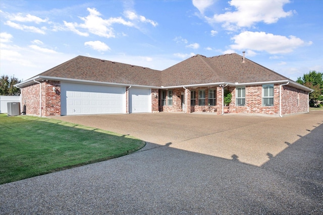 view of front of home with a front lawn, central AC unit, and a garage