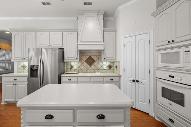 kitchen featuring white cabinets, white appliances, and light wood-type flooring