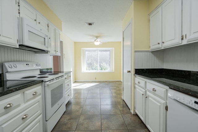 kitchen featuring white appliances, white cabinetry, and dark tile patterned floors