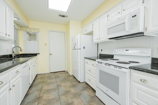 kitchen with white cabinetry, ceiling fan, a textured ceiling, white appliances, and dark tile patterned flooring