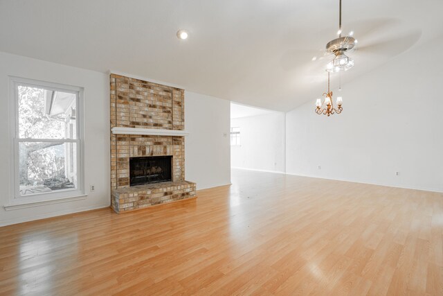 unfurnished room featuring a towering ceiling, ceiling fan with notable chandelier, and light hardwood / wood-style floors