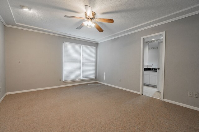 unfurnished room with a textured ceiling, light carpet, ceiling fan, and crown molding