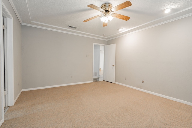 empty room with a textured ceiling, ornamental molding, visible vents, and light colored carpet