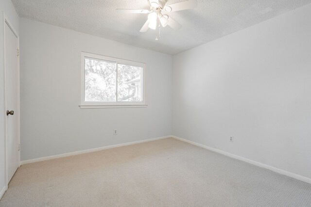 unfurnished bedroom with a textured ceiling, light carpet, and ceiling fan