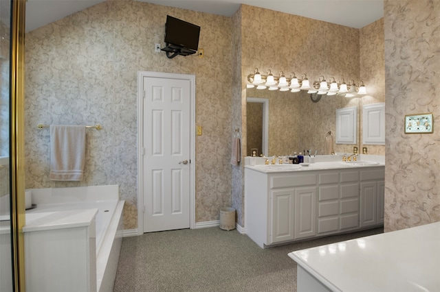 bathroom featuring vanity, lofted ceiling, and a bath