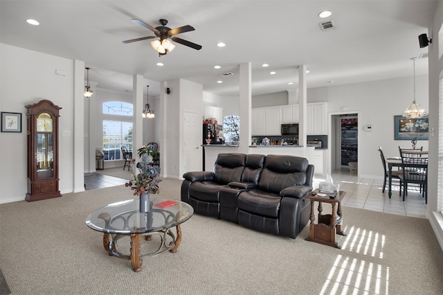 carpeted living room featuring ceiling fan with notable chandelier