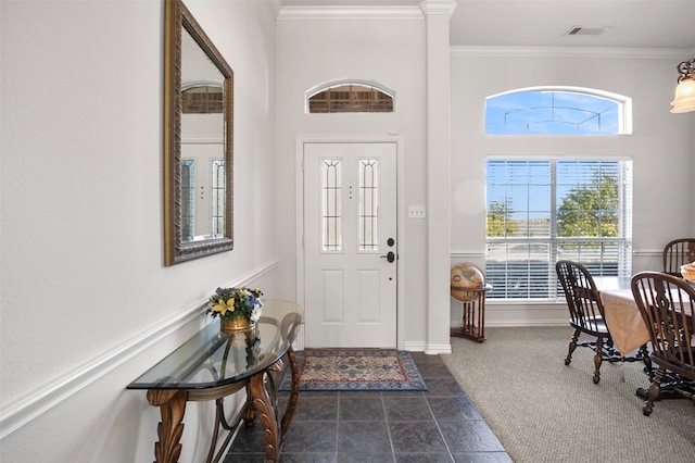 tiled foyer entrance featuring a towering ceiling and ornamental molding