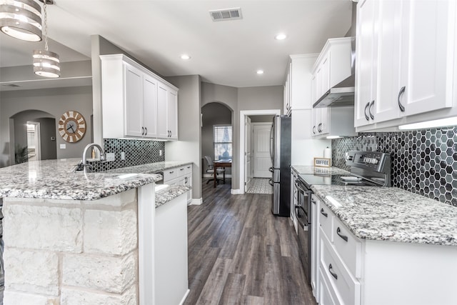 kitchen with dark hardwood / wood-style floors, hanging light fixtures, stainless steel appliances, light stone countertops, and white cabinetry