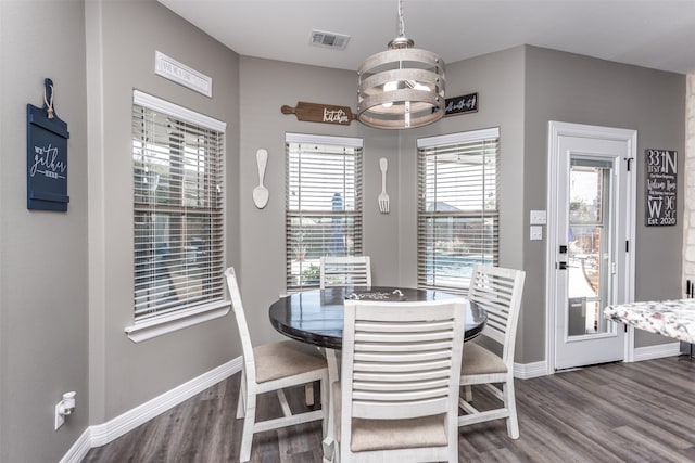 dining space featuring a wealth of natural light, a chandelier, and dark hardwood / wood-style floors