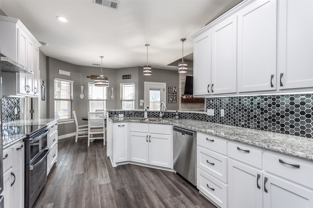 kitchen with dark hardwood / wood-style floors, appliances with stainless steel finishes, decorative light fixtures, and white cabinets