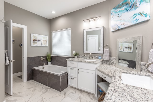 bathroom with vanity and tiled bath