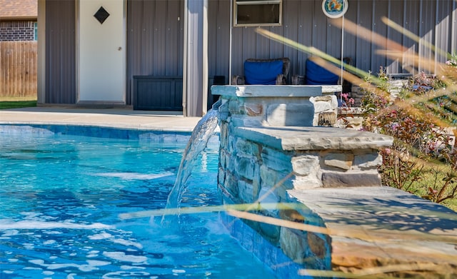 view of swimming pool with pool water feature