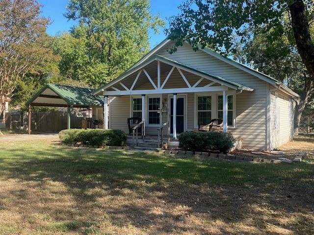 bungalow with a porch, a carport, and a front lawn