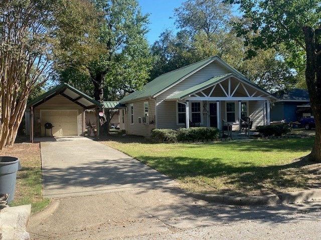 bungalow featuring a garage, an outdoor structure, and a front yard