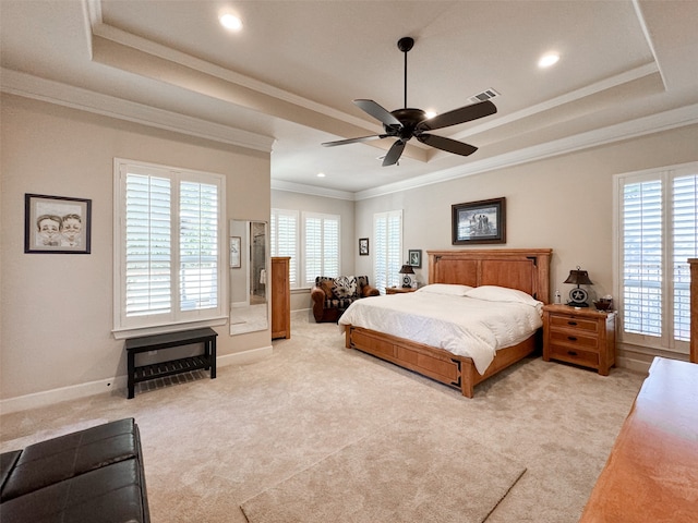 carpeted bedroom featuring ceiling fan, crown molding, and a tray ceiling