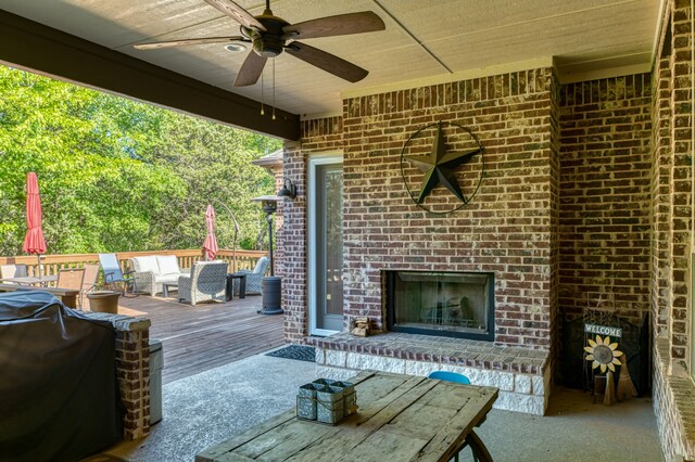 deck with an outdoor living space with a fireplace and ceiling fan