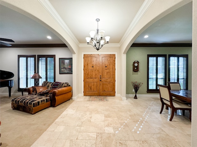 foyer featuring crown molding, a wealth of natural light, and ceiling fan with notable chandelier