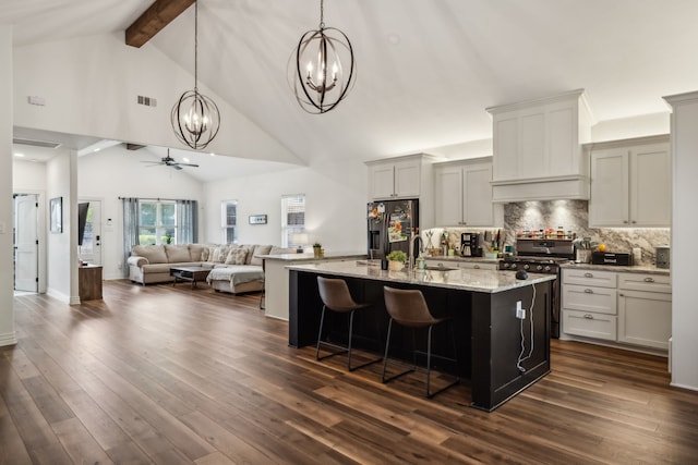 kitchen with ceiling fan, a kitchen island with sink, stainless steel refrigerator with ice dispenser, and dark hardwood / wood-style flooring