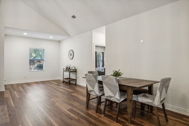 dining room with high vaulted ceiling and dark hardwood / wood-style floors