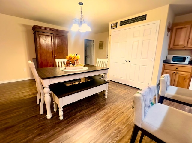 dining area featuring hardwood / wood-style flooring and a notable chandelier