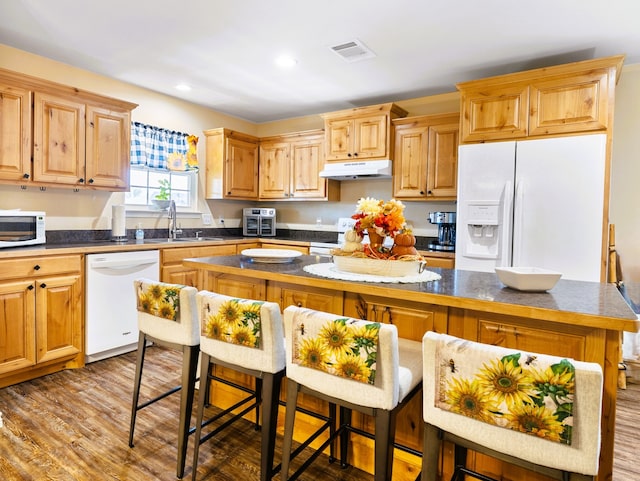 kitchen with a center island, white appliances, sink, and light hardwood / wood-style flooring