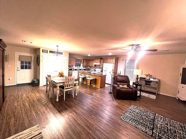 dining room featuring ceiling fan, dark hardwood / wood-style flooring, and a textured ceiling