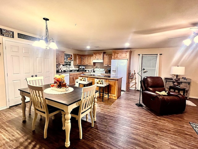 dining area featuring dark hardwood / wood-style floors, sink, and ceiling fan with notable chandelier