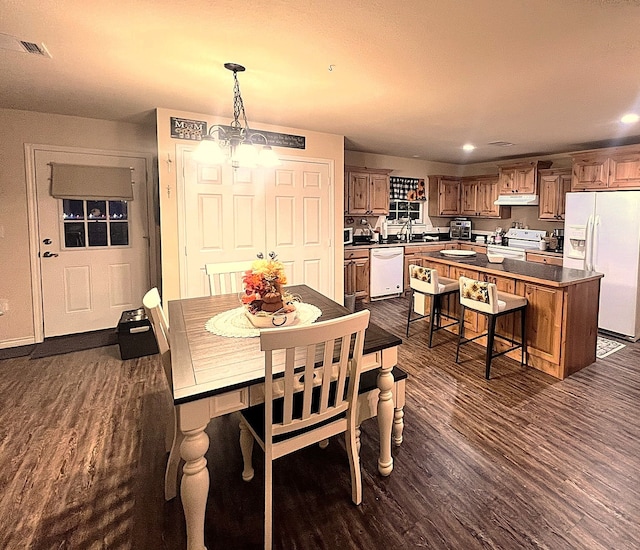 dining room featuring dark hardwood / wood-style flooring, a chandelier, and sink