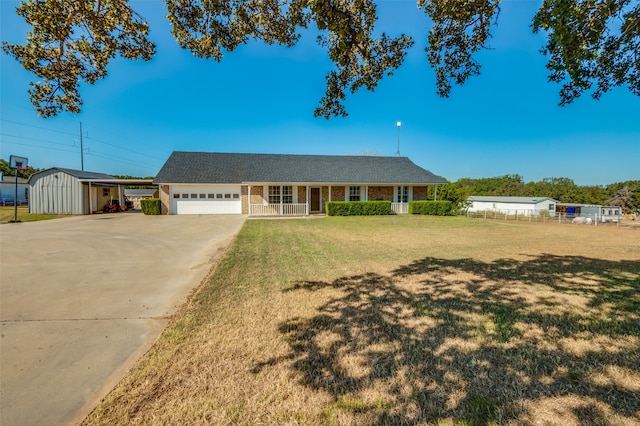 ranch-style house with covered porch, a storage unit, a front lawn, and a garage