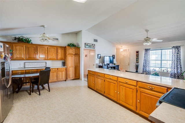 kitchen with stainless steel fridge with ice dispenser, range, ceiling fan, and vaulted ceiling