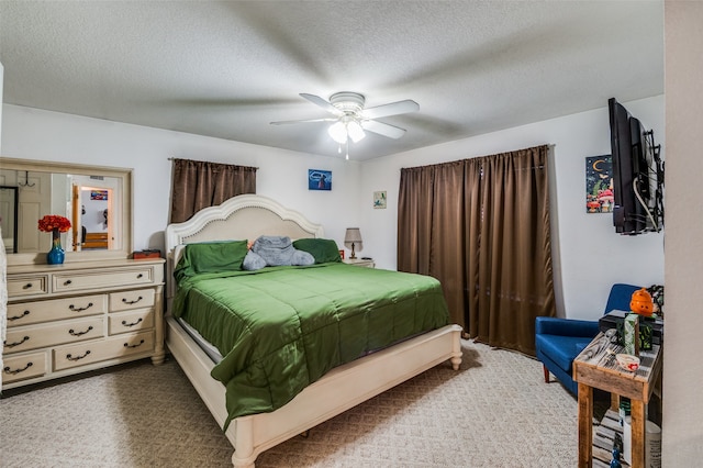 carpeted bedroom featuring ceiling fan and a textured ceiling