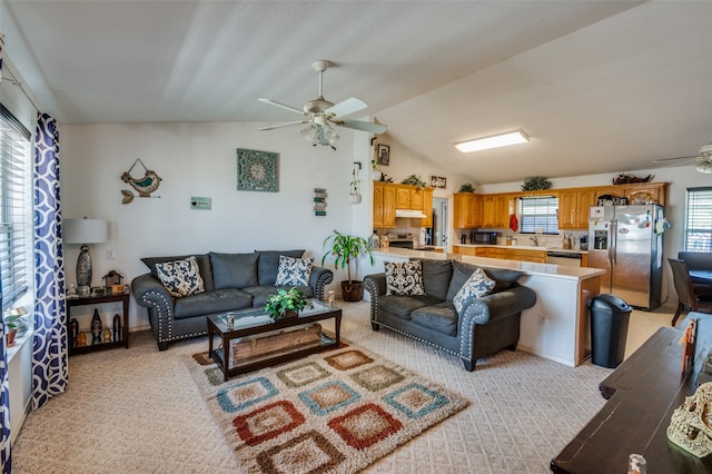 carpeted living room with sink, ceiling fan, and lofted ceiling