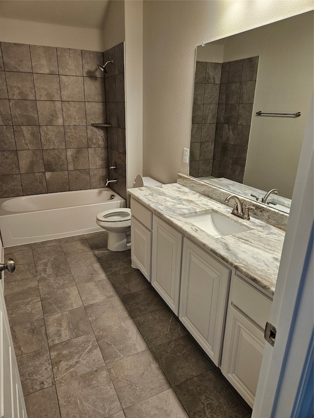 full bathroom with tiled shower / bath, vanity, and toilet