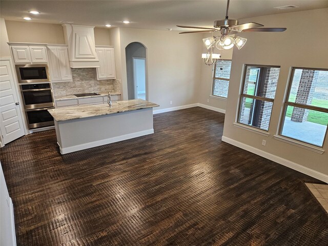 kitchen featuring white cabinetry, built in microwave, light stone countertops, dark hardwood / wood-style flooring, and double oven