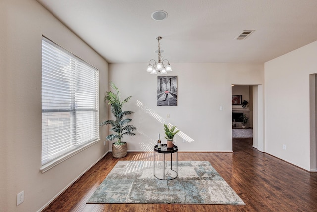 dining area featuring a chandelier, dark hardwood / wood-style floors, and a healthy amount of sunlight