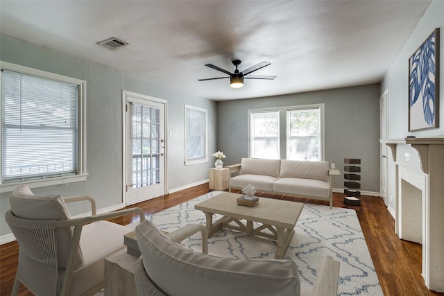 living room featuring ceiling fan and dark hardwood / wood-style flooring