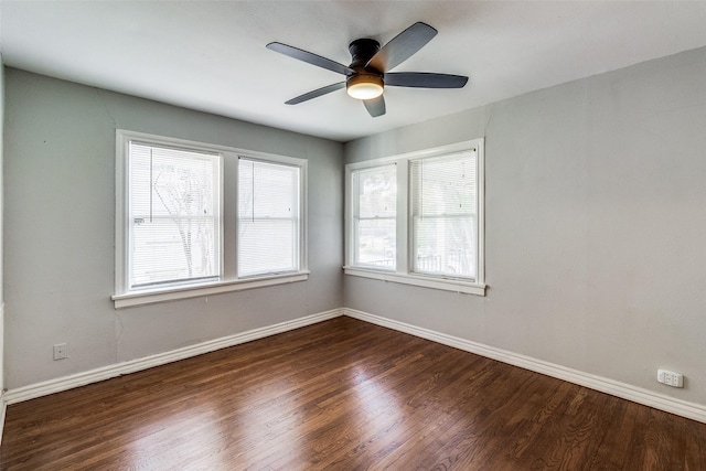 empty room featuring a wealth of natural light, dark wood-type flooring, and ceiling fan