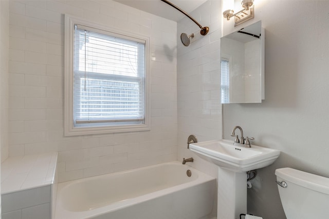 full bathroom with plenty of natural light, toilet, sink, and tiled shower / bath combo