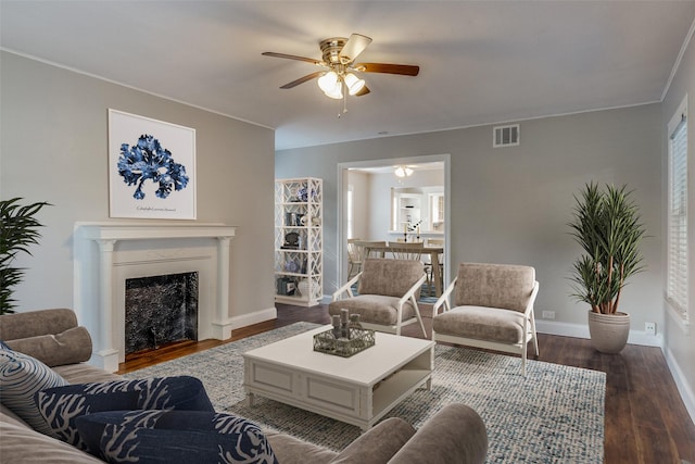 living room featuring ceiling fan, dark hardwood / wood-style flooring, and a premium fireplace