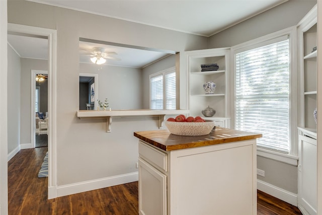 kitchen with wood counters, a center island, white cabinets, dark hardwood / wood-style floors, and ceiling fan