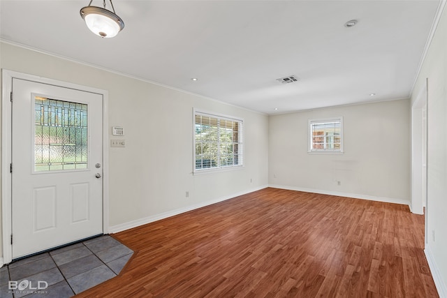 foyer with hardwood / wood-style flooring, plenty of natural light, and crown molding