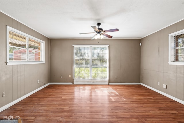 empty room with hardwood / wood-style flooring, ceiling fan, and a healthy amount of sunlight