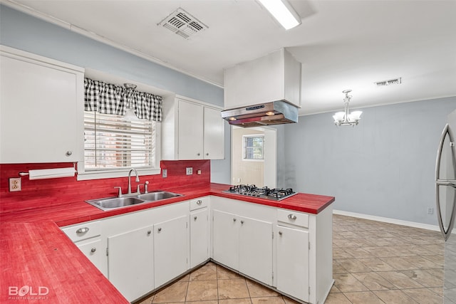 kitchen with premium range hood, tasteful backsplash, sink, and white cabinets