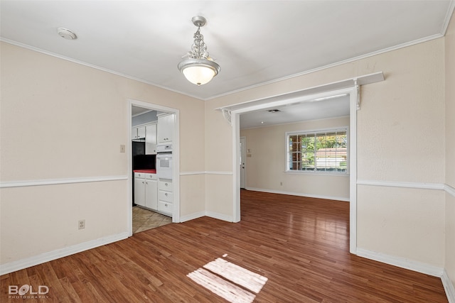 unfurnished dining area featuring wood-type flooring and crown molding