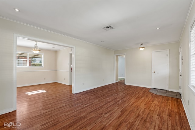 unfurnished room with hardwood / wood-style flooring and ornamental molding