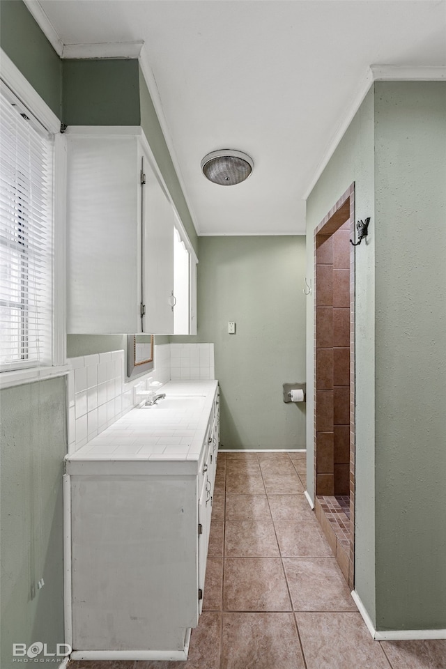 bathroom with vanity, backsplash, tile patterned floors, and crown molding